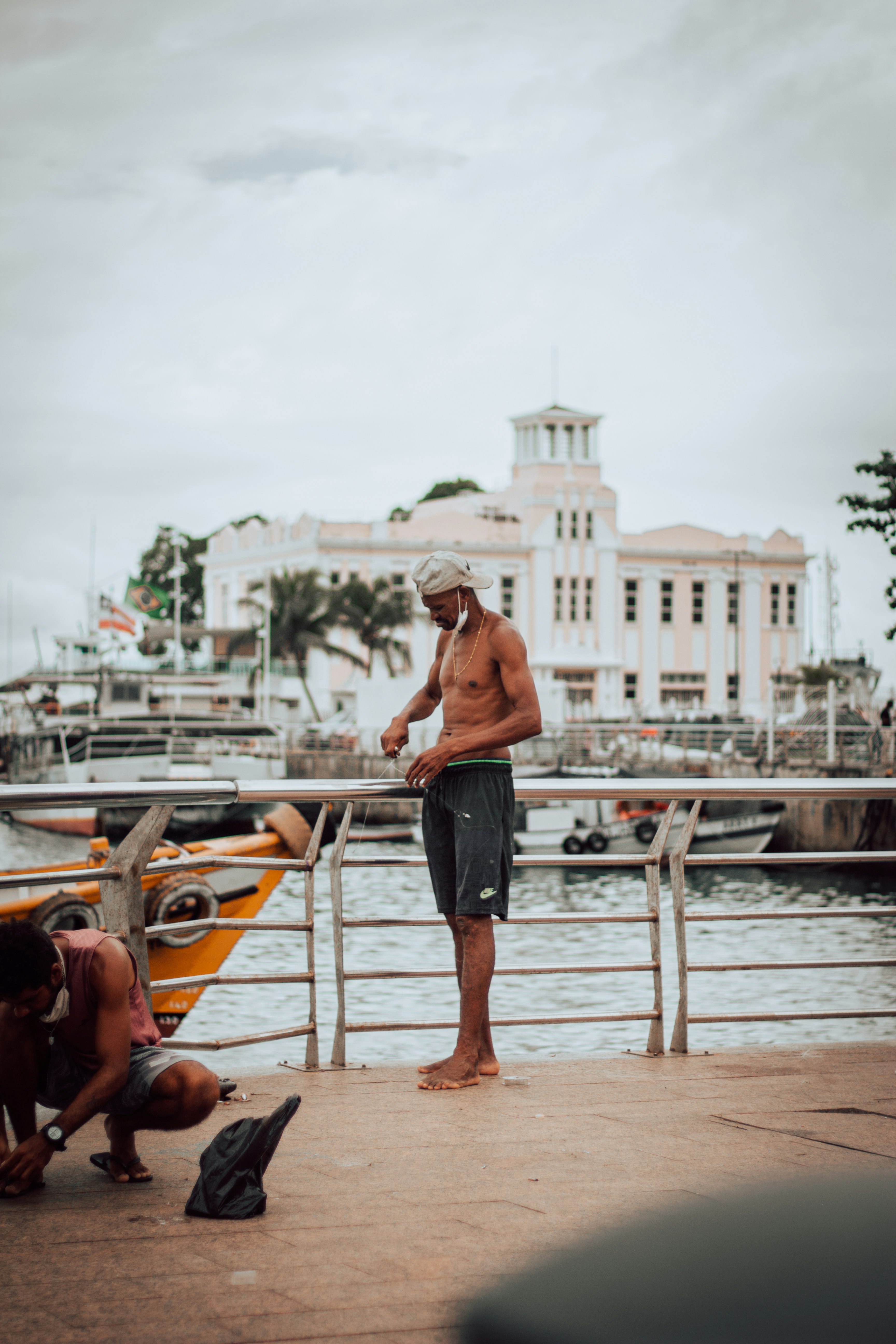 man in black shorts walking on brown wooden dock during daytime